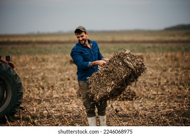 Good looking hard working man wearing boots and a shirt grabs a hay bale stacked in the western barn. - Powered by Shutterstock