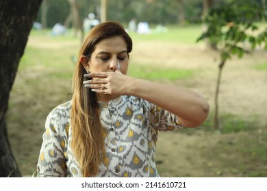 Good looking Indian woman doing yoga in the park in day time. Mid aged woman practicing yoga morning.