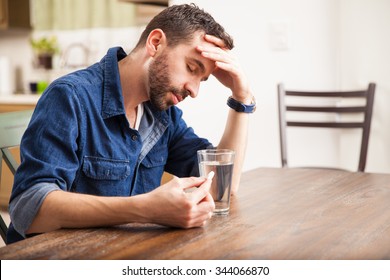 Good Looking Man With A Beard Feeling Sick With Indigestion And About To Drink An Effervescent Tablet At Home