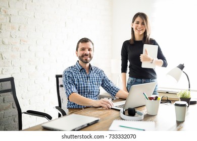 Good Looking Man On His First Day Of Work Sitting Using The Computer While Being Supervised By His Female Boss