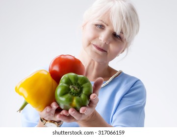 Good Looking Senior Woman Holding Fresh Vegetables In Hand. Healthy Lifestyle Concept. 