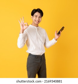 Good Looking Teenage Asian Man With Laugh Isolate On Yellow Background Show Ok Sign For Appreciation