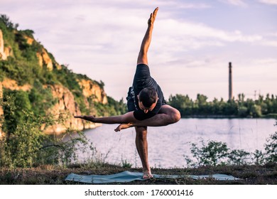 A good looking young bearded man doing yoga on quarry lake backdrop. International Day of Yoga concept. - Powered by Shutterstock