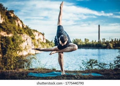 A good looking young bearded man doing yoga on quarry lake backdrop. International Day of Yoga concept. - Powered by Shutterstock