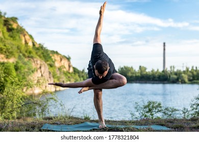 A good looking young bearded man doing yoga on quarry lake backdrop. International Day of Yoga concept. - Powered by Shutterstock