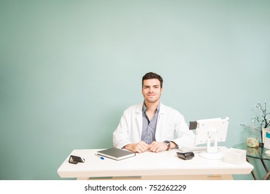 Good Looking Young Male Therapist Sitting At The Front Desk Of A Spa With Tons Of Copy Space