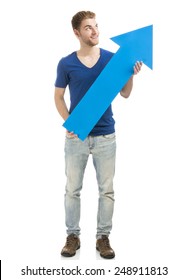 Good Looking Young Man Holding A Blue Arrow, Isolated On A White Background