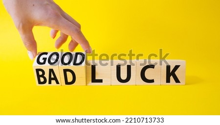 Good Luck and bad Luck symbol. Hand turns a cube and changes the words Bad Luck to Good Luck. Beautiful yellow background. Businessman hand. Business concept. Copy space