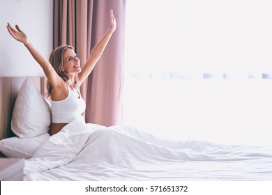 Good Morning! Pretty Young Woman Stretching Hands Up At Her Bed At Home.