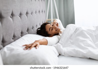 Good Morning. Satisfied Young African American Woman Stretching After Wake Up, Feeling Good, Charming Black Lady Sleeping And Lying On The White Bedsheets At Home, Relaxing In Bedroom