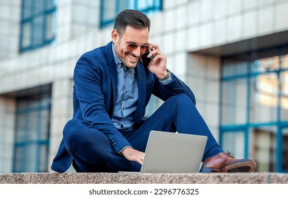 Good news. Happy smiling businessman talking with his client via smartphone while checking data on laptop. Business, lifestyle concept - Powered by Shutterstock