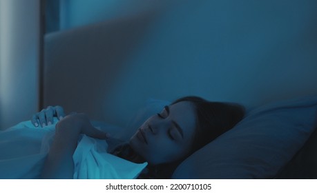 Good Night. Sweet Dreams. Sleeping Woman. Relaxed Calm Lady In Comfortable Bed In Dark Bedroom With Blue Moonlight.