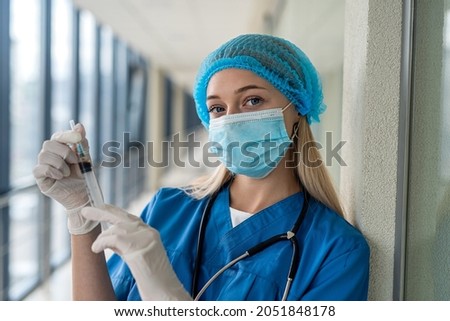 a good nurse in uniform with a stethoscope in gloves and a mask holds a syringe. Medicine concept