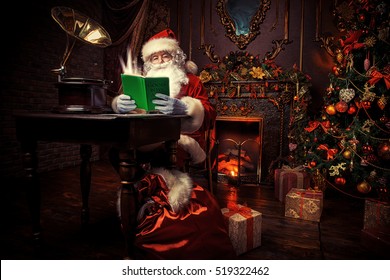 Good old Santa Claus in his house next to the fireplace and Christmas tree ready for Christmas. 