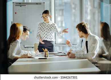 Good Psychologist. Pleasant Young Female Boss Having A Meeting With Her Employees And Trying To Solve A Conflict Between Them