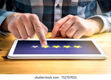 Good review. Satisfied and happy customer giving great rating with tablet on an imaginary criticism site, application or website. Four out of five stars. Man using mobile device home.