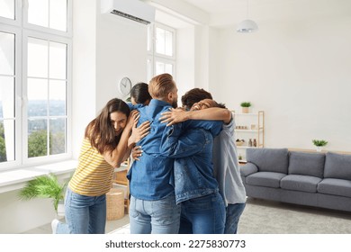 It's good to see you all again. Friends meet after long separation. Joyful friends standing and hugging. Group of diverse people having fun and congratulating each other on happy life event - Powered by Shutterstock