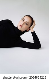 Good Series Of Photos Of Young Pretty Woman. Studio. European Type, Big Lips, Awesome Eyes, Slim Body. White Background. Black Clothes. Emotional. Minimalism. Stylish. Fashionable And Modern Lifestyle