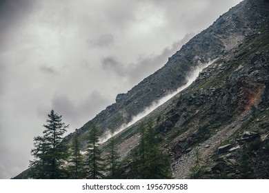 Good Shot Of Rockfall On Rocky Mountain Steep Slope And Long Trail Of Dust. Good Moment Of Dangerous Scene With Falling Stones And Boulder From Rocks. Rockfall In Mountains. Dusty Plume Of Rockfall.