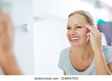 Good Skincare Habits Will Have You Looking Younger. Cropped Shot Of A Mature Woman Inspecting Her Skin In Front Of The Bathroom Mirror.