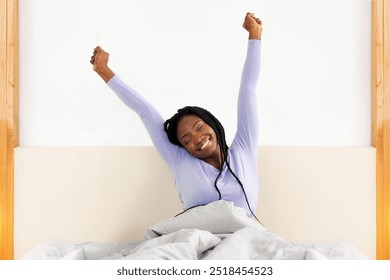 Good Sleep. Happy Rested Black Lady Stretching Arms Waking Up Sitting In Comfortable Bed In Bedroom At Home. Copy Space - Powered by Shutterstock