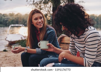 Good Talk With Friend. Two Young Beautiful Women In Casual Wear Smiling And Talking While Enjoying Camping Near The Lake