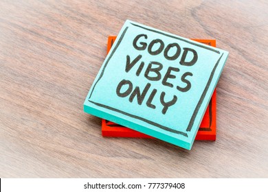 Good vibes only reminder - handwriting on a sticky note against grained wood