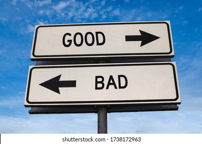 Good Vs Bad. White Two Street Signs With Arrow On Metal Pole With Word. Directional Road. Crossroads Road Sign, Two Arrow. Blue Sky Background. Two Way Road Sign With Text.