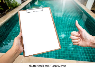 Good water quality, Girl hand holding blank paper clipboard over clear swimming pool water background