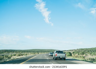 Good Weather Sight Of Pickup Car And Compact Driving Ahead On Straight Roadway. Road Trip Vehicles Running On Route With Azure Sky Overhead.