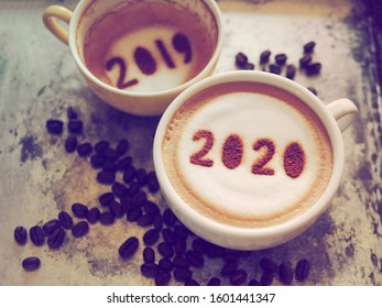 Goodbye 2019 Hello 2020 Theme Coffee Cups With Number 2020 And 2019 Over Frothy Surface Serving In Rustic Aluminum Tray With Coffee Beans. New Year New You, Holidays Food Art Concept. (top View)