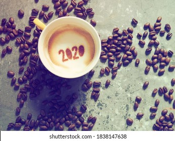 Goodbye 2020, A Year That Many Want Time To Flies By. Holidays Food Art Theme Coffee Cup With Coffee Stain And Number 2020 At Bottom Of Cup On Cement Background With Coffee Beans. New Year New Life.