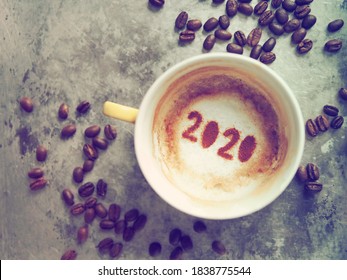 Goodbye 2020, A Year That Many Want Time To Flies By. Holidays Food Art Theme Coffee Cup With Coffee Stain And Number 2020 At Bottom Of Cup On Rustic Aluminum Tray With Coffee Beans. New Year New Life