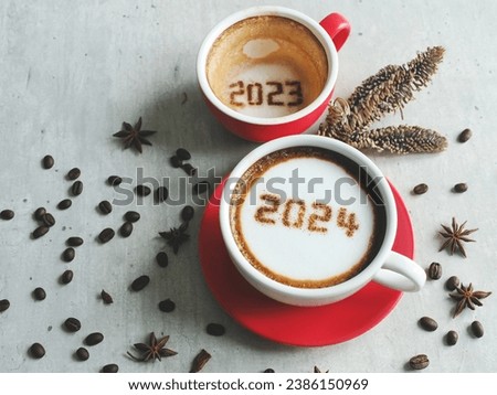 Goodbye 2023 Hello 2024 theme coffee cups with number 2024 and 2023 over frothy surface on white cement background with coffee beans, star anise, dried pine branch. Holidays food art Happy New Year.