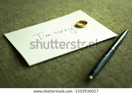 A goodbye note with a wedding ring and pen at home. Divorce. 