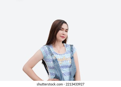 A Good-looking Asian Woman Winks In A Flirty Way As She Poses For The Camera With Her Hands On Her Hips. Isolated White Background Studio Shot.