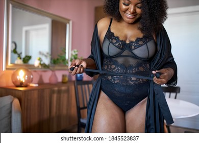 good-looking black woman wearing silk dressing gown at home, attractive female has pretty sexy plus size figure. indoors