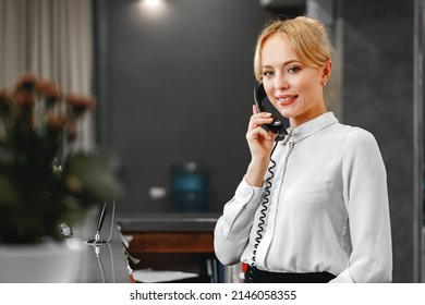 Good-looking Friendly Woman Hotel Receptionist Talking On The Phone