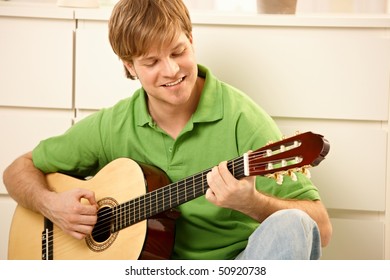 Goodlooking Guy Playing Guitar At Home.