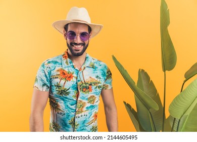 good-looking Hispanic man in casual summer clothes standing next to green leaves and enjoying with summer vacation concept medium shot studio shot orange background. High quality photo - Shutterstock ID 2144605495