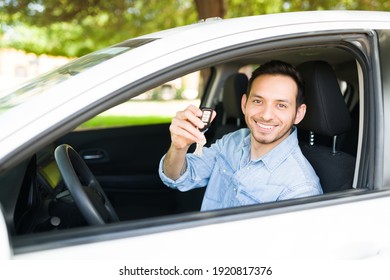 Good-looking Latin Man Sitting In The Driver's Seat And Showing His New Car Keys. Male Taxi Driver Happy To Start Working On A Mobile Transportation App