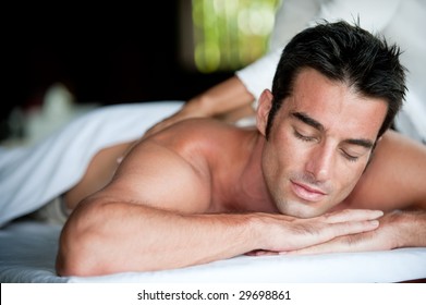 A good-looking man getting a back massage lying down