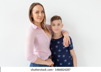 Good-looking Single-parent Mom And Teen Son On White Background. Cohesion, Friendship And Family Relations.