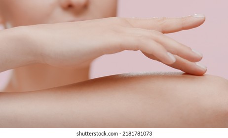 Good-looking young slim Caucasian woman strokes her forearm on pale pink background | Unwanted arm hair removal concept - Shutterstock ID 2181781073