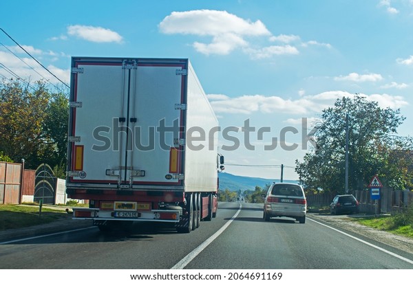 A goods transport\
truck makes a risky overtaking by stepping on the continuous line.\
Safety and attention while driving - concept. Romania, Simian.\
October, 26, 2021