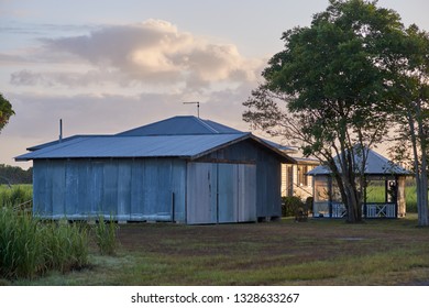 Goodwood Island, NSW / Australia - February 12 2019: A Rural Australian Farm Shed, And Outbuildings; All Painted Grey. Image Taken At Dawn In Summer, Among The Sugar Cane Fields.