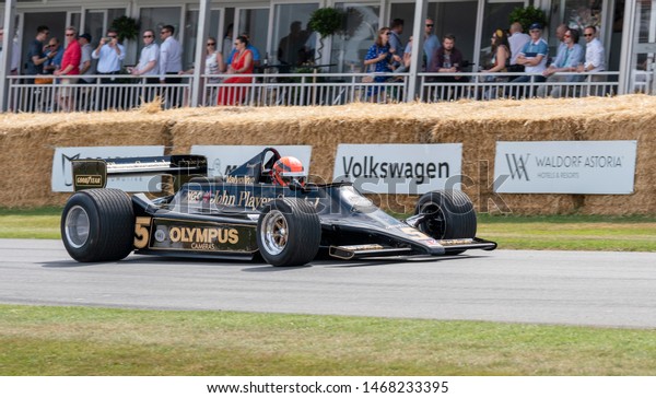 Goodwood, Sussex / UK - 6 July 2019: Clive\
Chapman drives a Lotus Cosworth 79, a 3.0 litre V8, up the hill at\
the Festival of Speed. This F1 car has black and gold livery\
sponsored by Olympus\
Cameras.