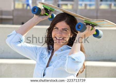 Goofy girl holding a skateboard on her head
