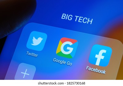 Google, Facebook, Twitter apps seen on the screen and dark blurred finger pointing at them. Stafford, United Kingdom - October 1 2020.