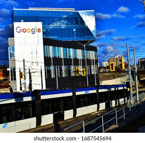 Google Glassy Building And Light Rail Train From Grand River Transit Passing Downtown Kitchener With A Traffic Lights And Cloudy Sky In Kitchener, Ontario, Canada, March 15, 2020.